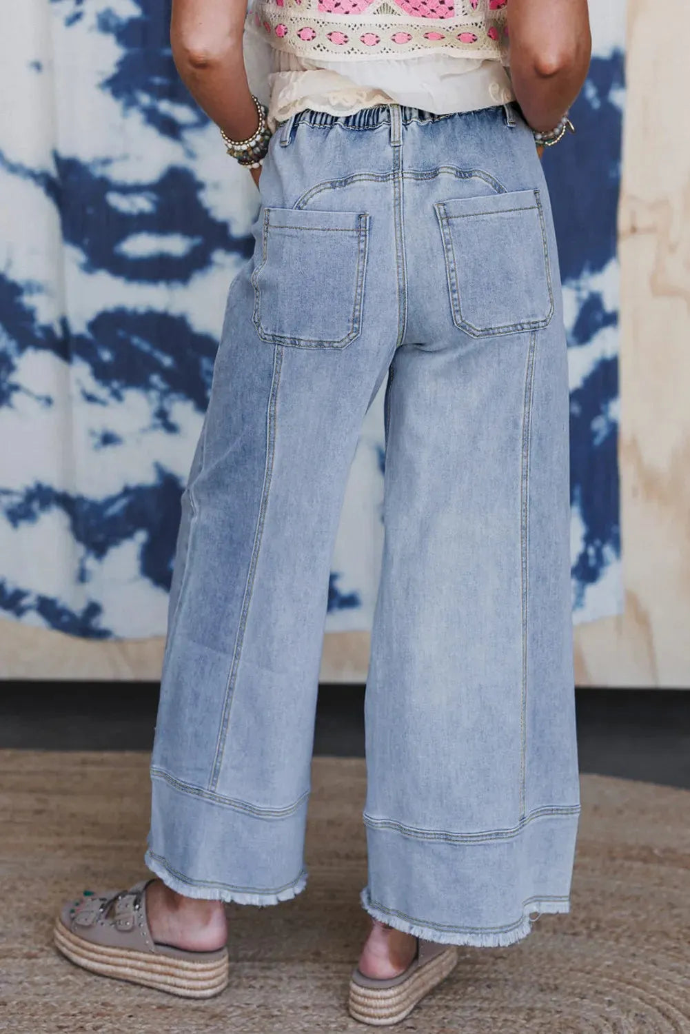 Beau blue women's wide-leg denim jeans with drawstring waist detailing and raw unfinished hem.