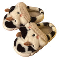 White plush cow-themed house slippers for women with a non-slip textured sole.