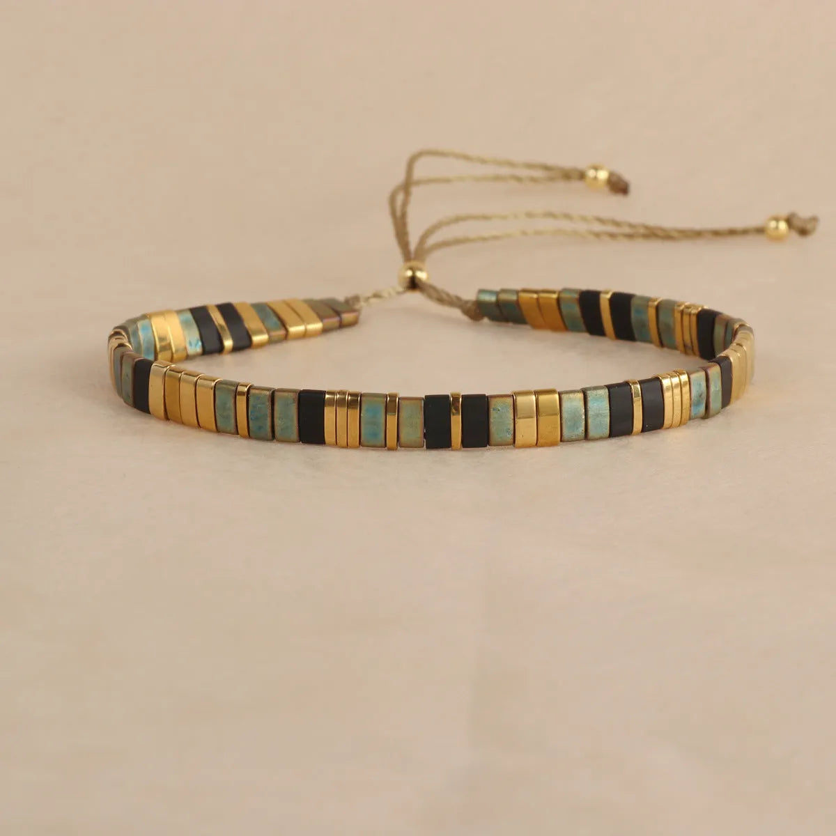 Geometric glass bead bracelet with pull beads design on a wrist, shown in milky white colour.