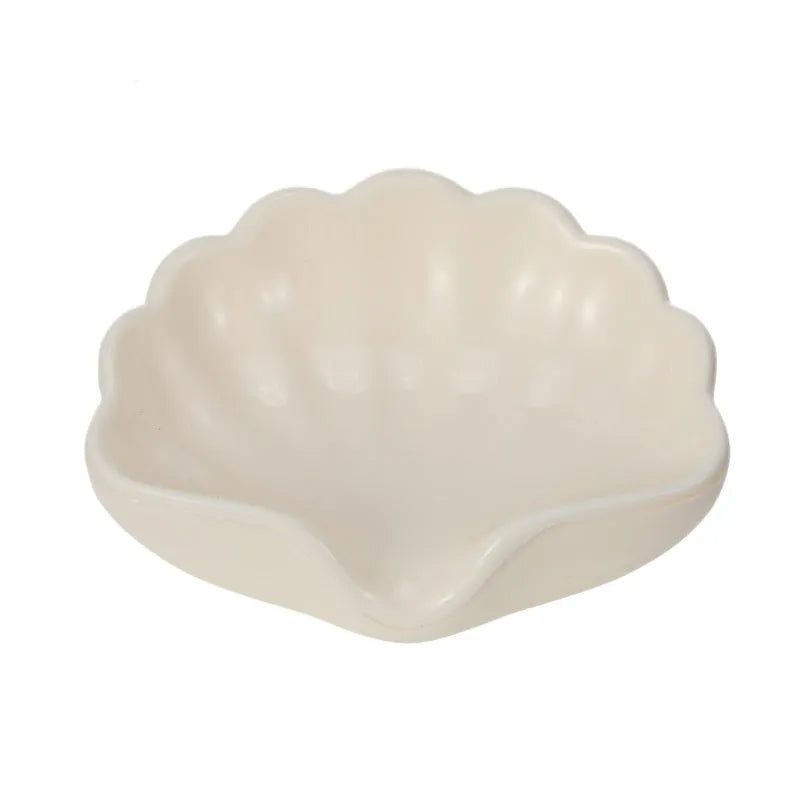 White and pink shell-shaped plastic soap dish for bathroom counter organisation.