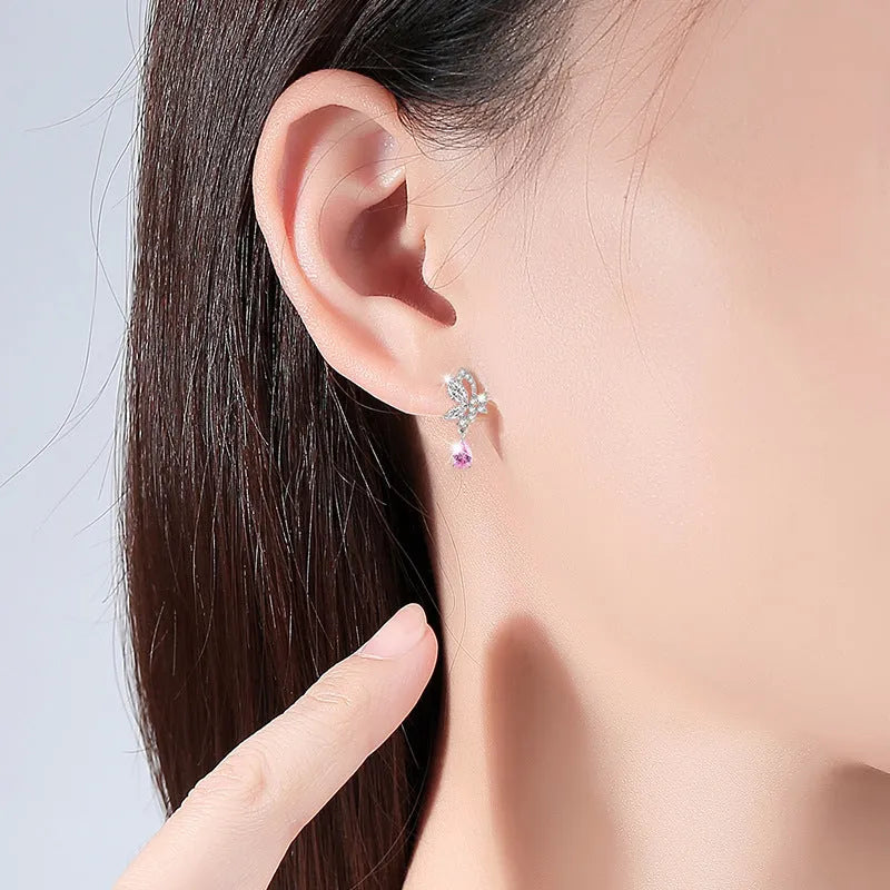 A pair of silver butterfly stud earrings with clear crystal details on a white background.