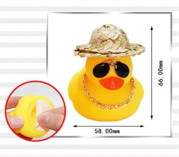 Matte yellow cartoon duck wearing a straw hat car ornament on a dashboard.