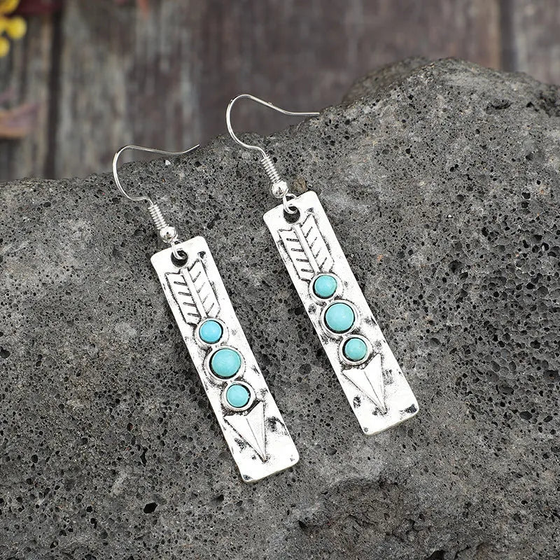 Long geometric silver earrings with turquoise stone accents and retro design
