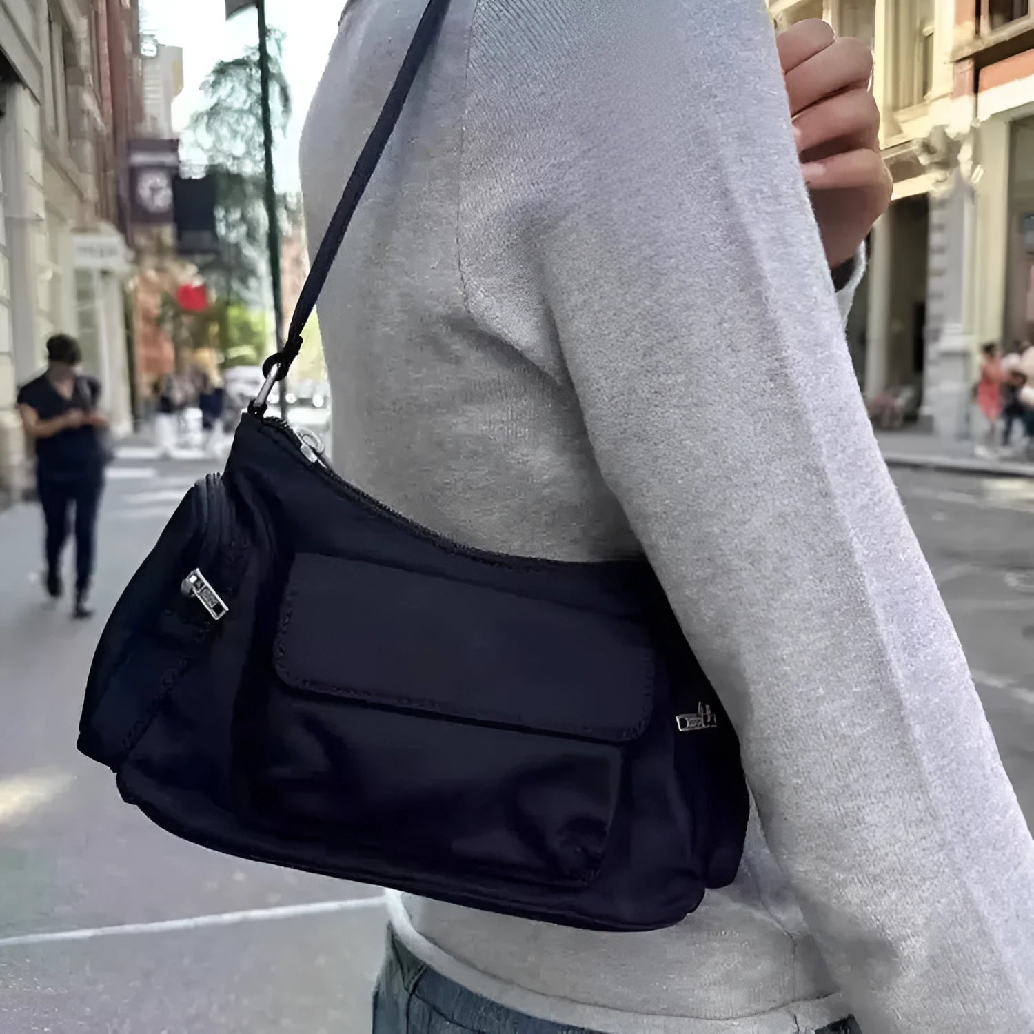 Black nylon lightweight shoulder bag with double pockets and side line detailing.