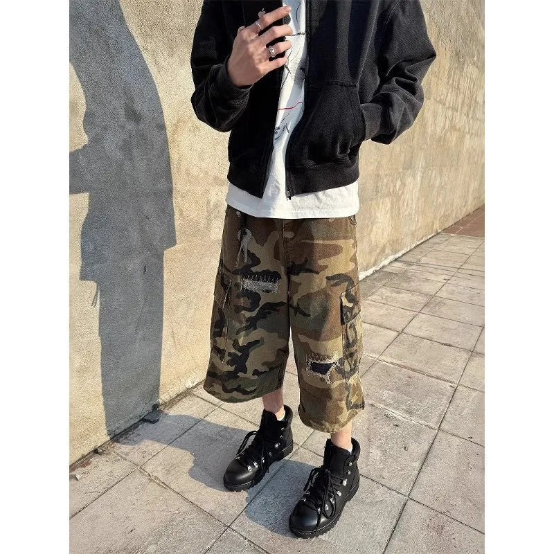 Men's retro patch ripped camouflage cropped jeans showing loose straight leg fit and distressed detailing