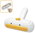 Yellow duck design portable manual pet hair remover tool on a fabric surface.