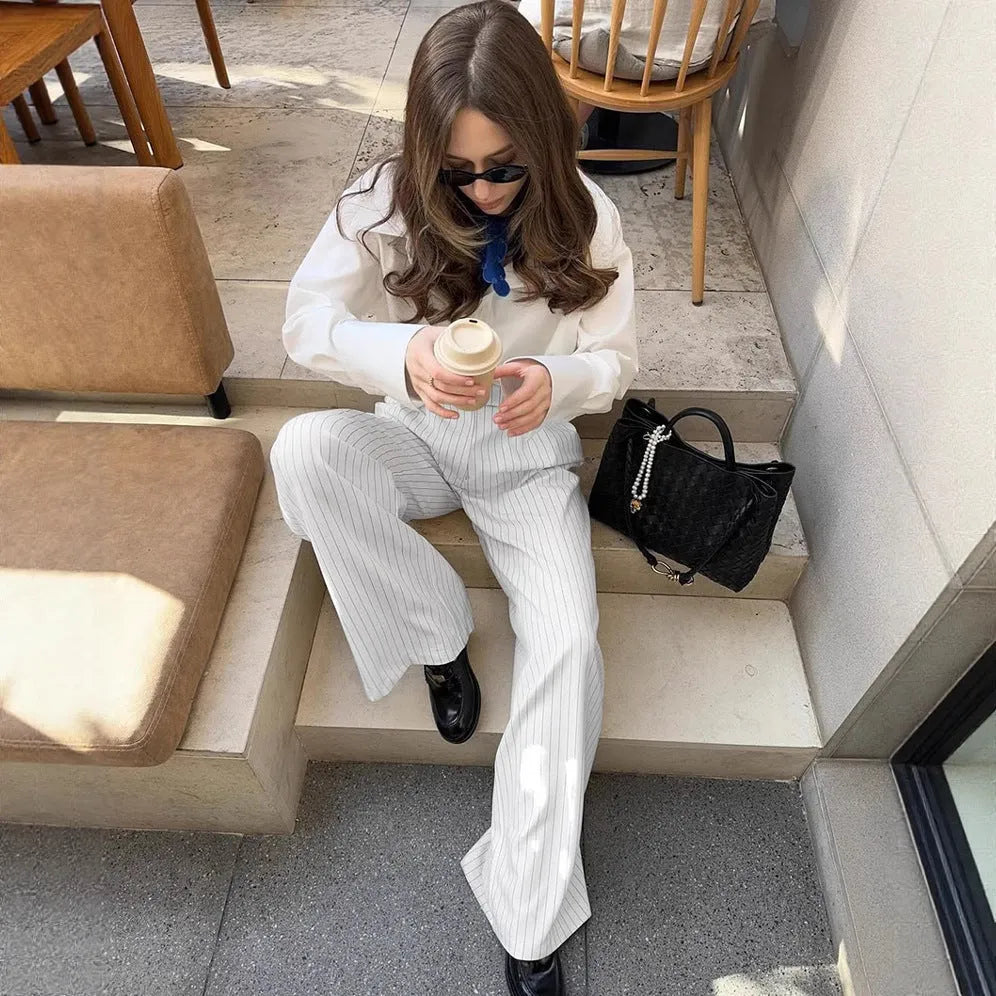 White striped wide-leg casual trousers with a zipper detail on a hanger.
