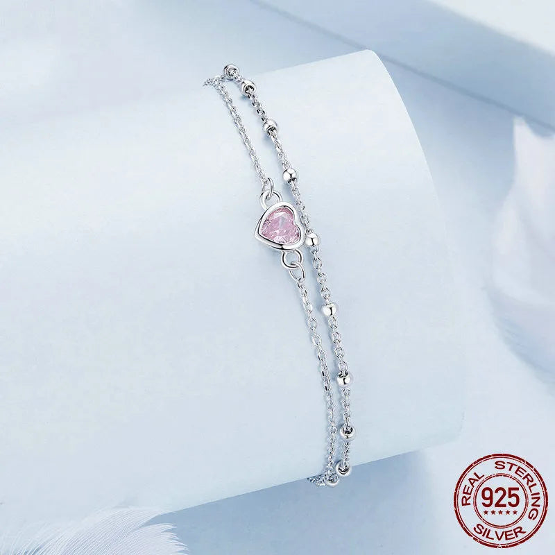 Women's sterling silver bracelet with a small heart-shaped charm on an adjustable chain.