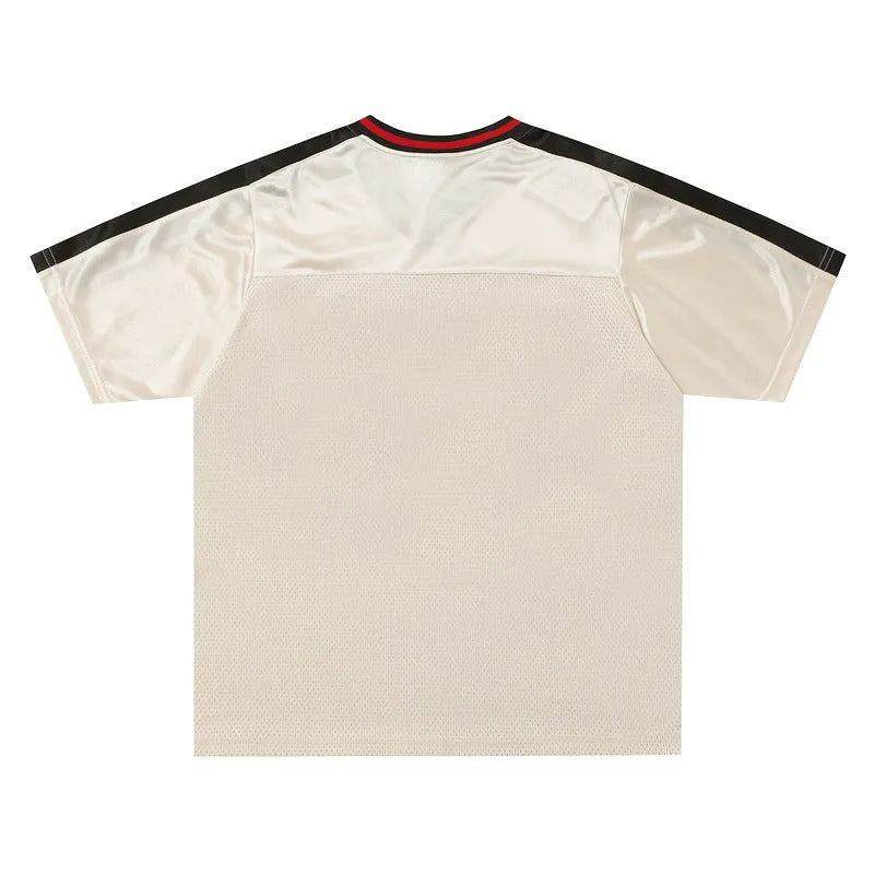 Apricot coloured loose V-neck pullover top with drop-shoulder sleeves and a letter pattern.