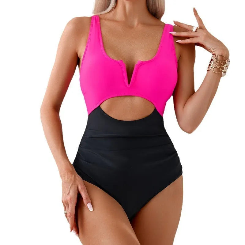 Women's one-piece swimsuit in a colour block pattern, shown in green, on a mannequin.
