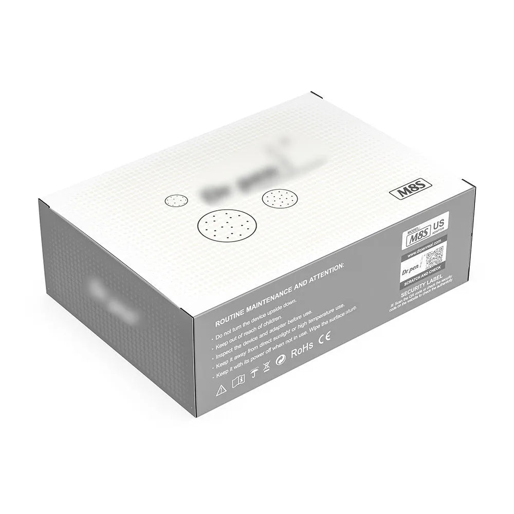 Grey wireless electric micro-needle pen with USB charging port lying on a flat surface