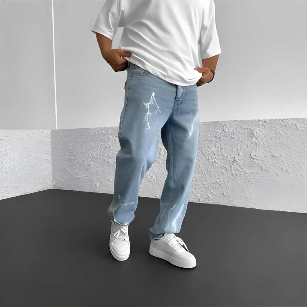 Men's blue straight-leg cotton denim trousers with a wide-leg fit and five-pocket design on a neutral background.