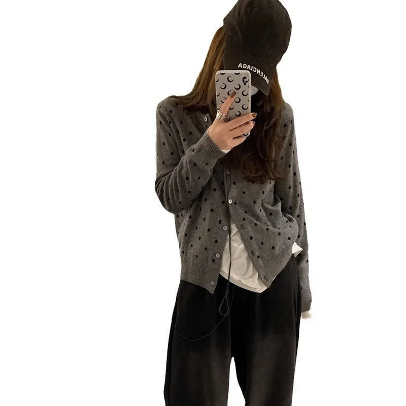Women's grey loose-fit knitted cardigan with long sleeves on a hanger.