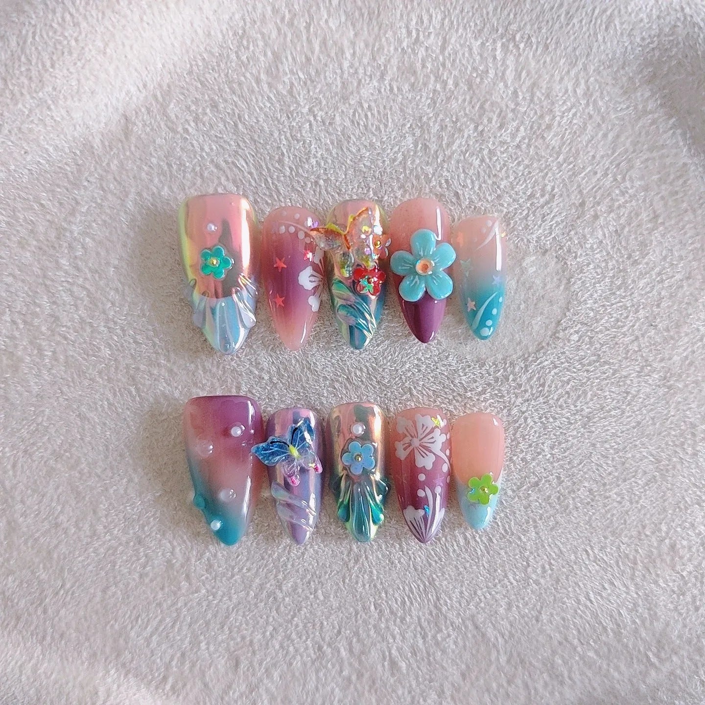Handmade embossed nail art stickers showing floral and butterfly patterns in almond shape