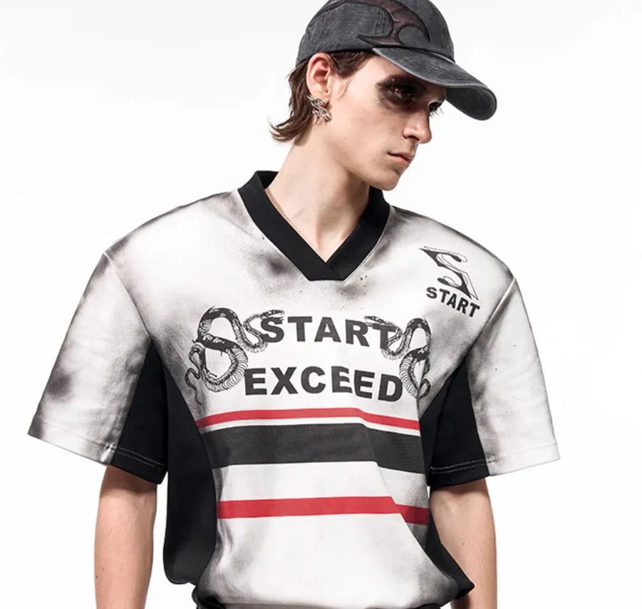 Women's V-neck short sleeve top with snake letter print and padded shoulders on a hanger.