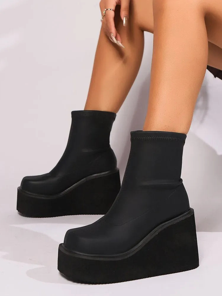Plus size women's black faux leather wedge heel ankle boots with round toe on a waterproof platform sole.