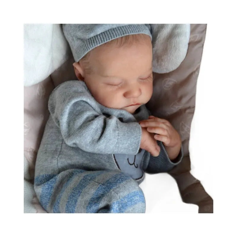 18-inch reborn doll with cloth body in soft pink romper sitting on table