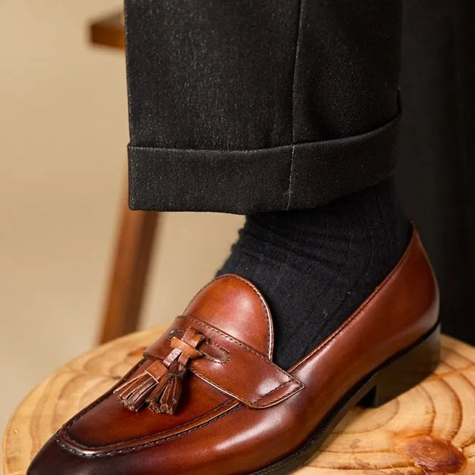 Men's black polished leather tassel loafers with a pigskin lining and rubber sole