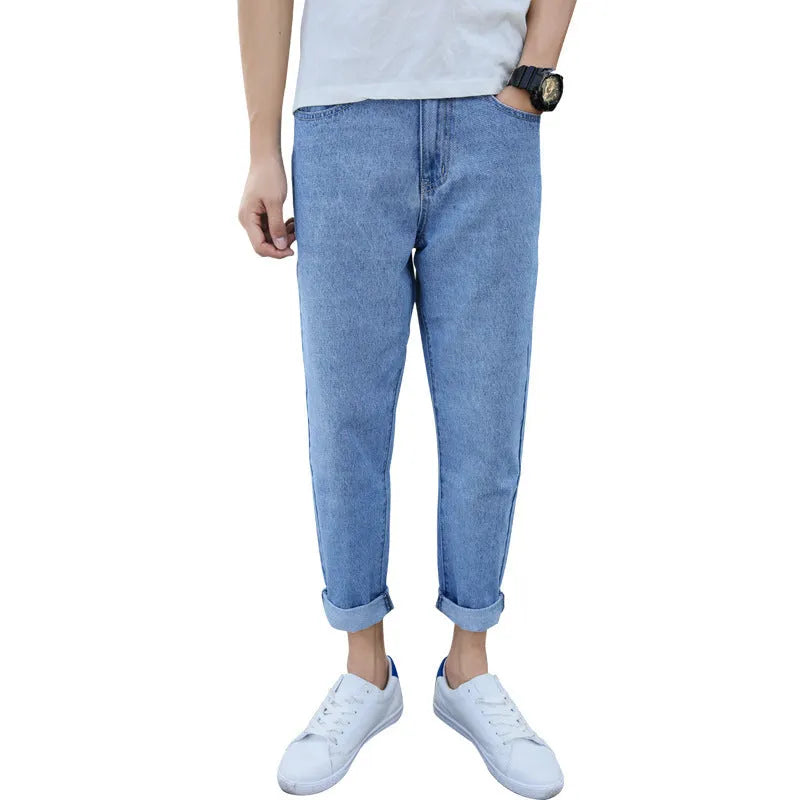 Man wearing black loose fit straight leg cotton jeans, showcasing the high-rise harem style and light straight leg opening.