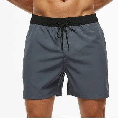 Men's blue athletic shorts with stitching waist detail and zipper pockets for running and fitness