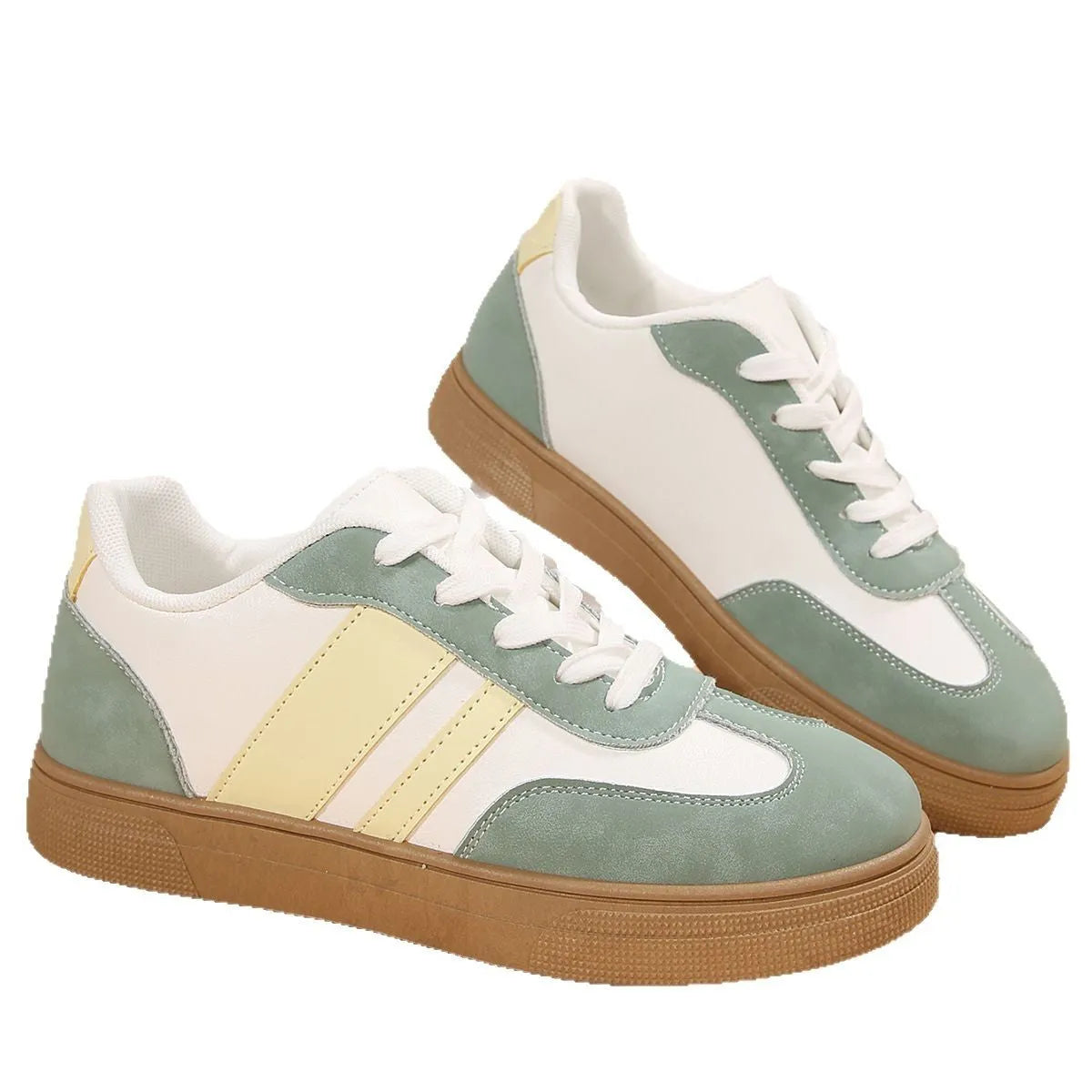 Green women's retro sports shoes with white cross-strap detail and leather stitching on a low rubber sole.