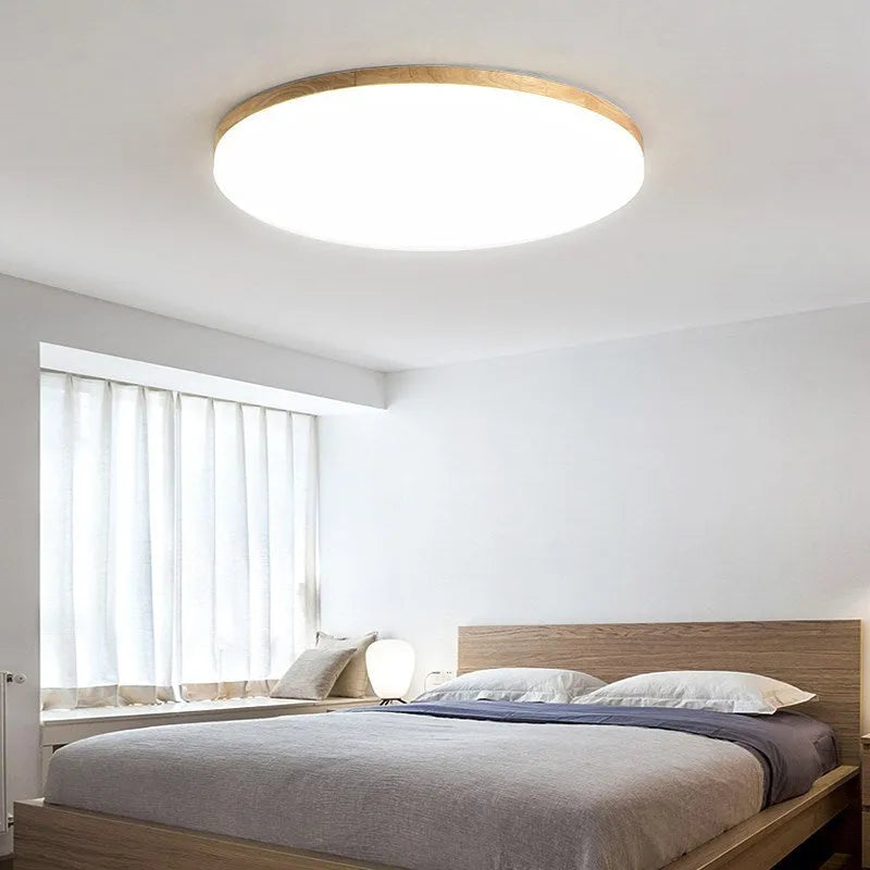 Japanese minimalist wood and acrylic LED ceiling lamp with a round acrylic shade on a wood body.