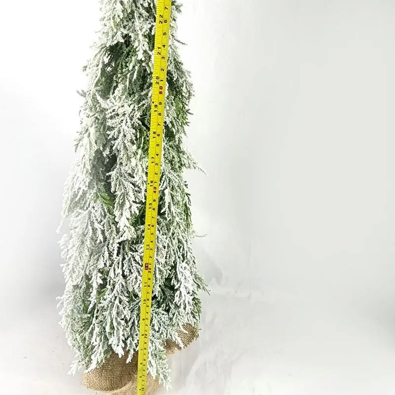 Small 24 inch artificial Christmas tree with lights and snow effect on a desktop