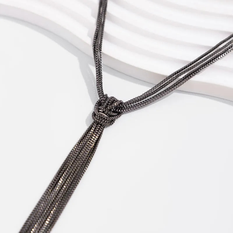 Simple Y-shaped metal tassel necklace with minimalist understated style, colour Gold, on display with matching earrings.