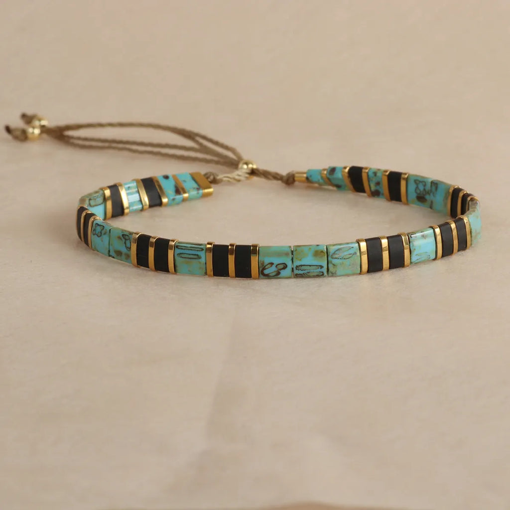 Geometric glass bead bracelet with pull beads design on a wrist, shown in milky white colour.