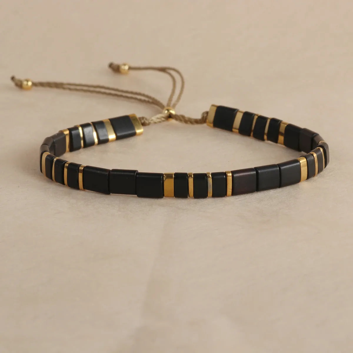 Geometric glass bead bracelet with pull beads design on a wrist, shown in milky white colour.