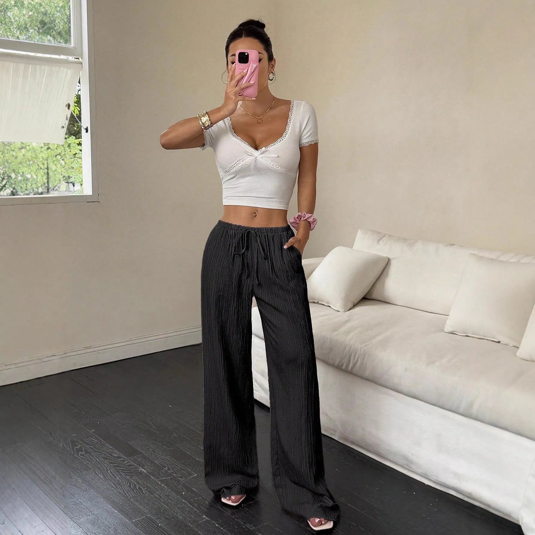 Women's black wide leg trousers with lace-up waist trimming showing adjustable detail