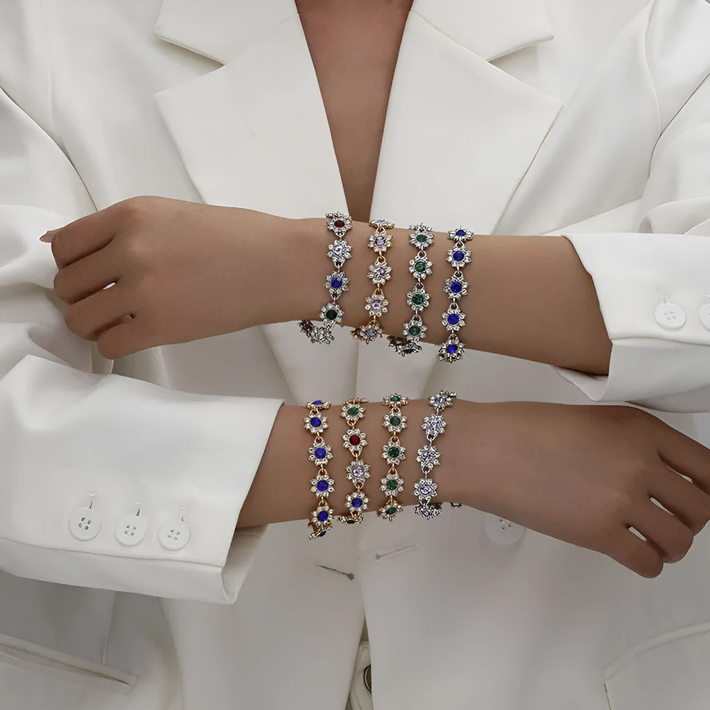 Floral shaped zinc alloy bracelet with electroplated silver finish and red coloured gemstones.