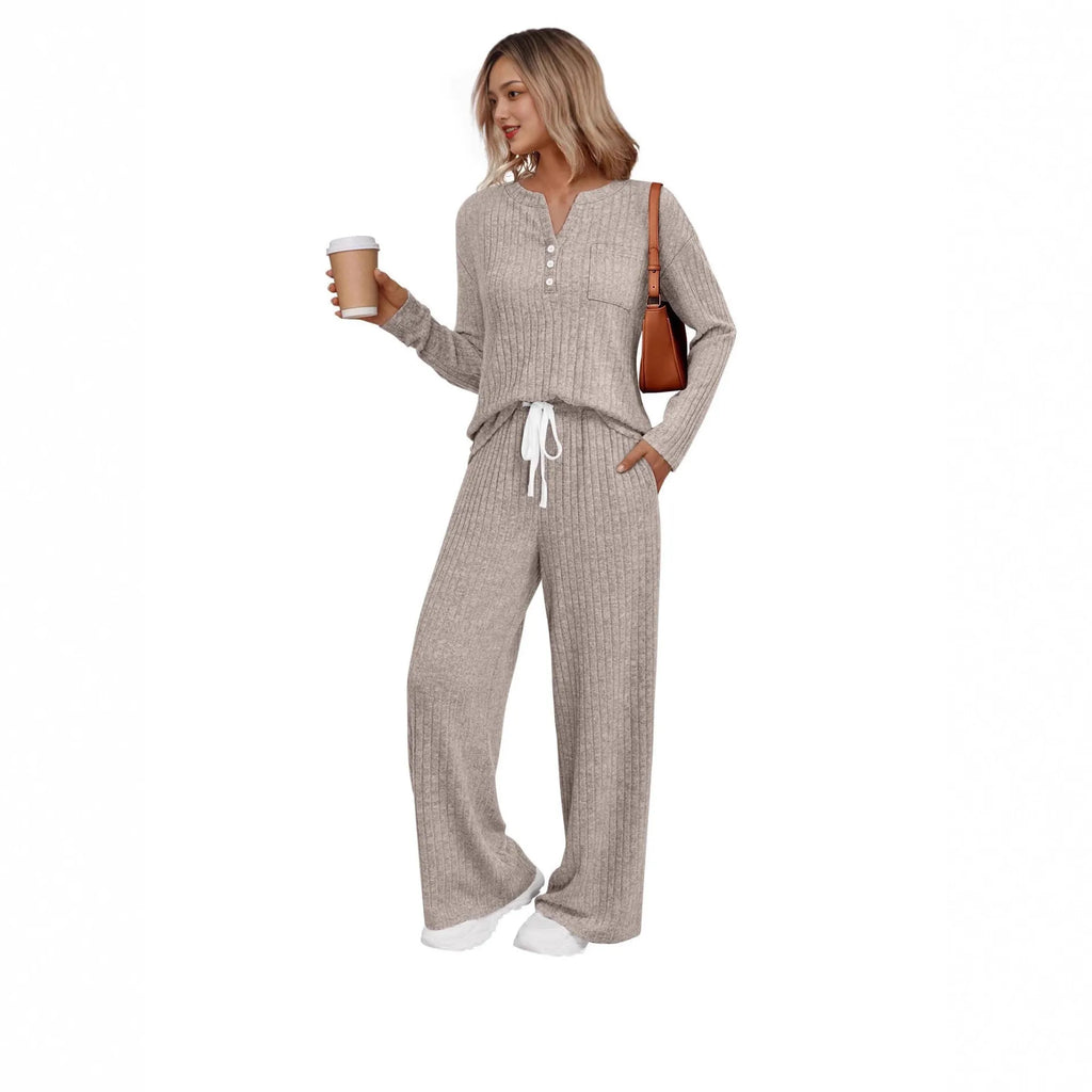 Woman wearing a striped knitted V-neck long coat with matching pants in a light grey colour.