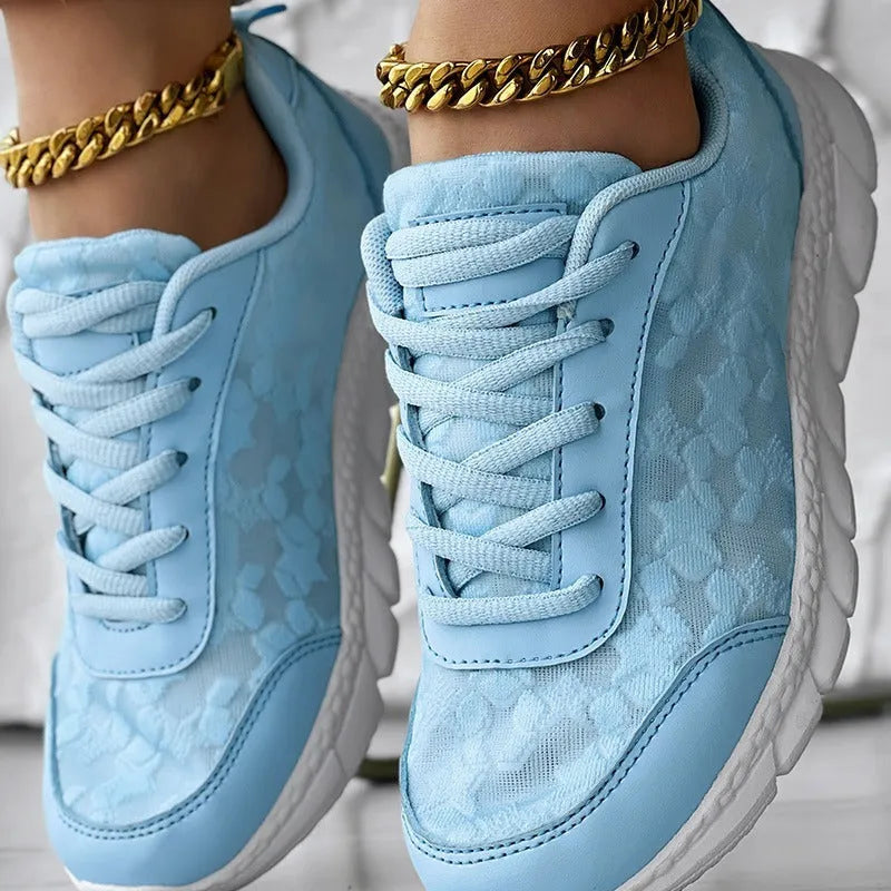 Women's white canvas running shoes with soft sole and round toe on a flat heel.