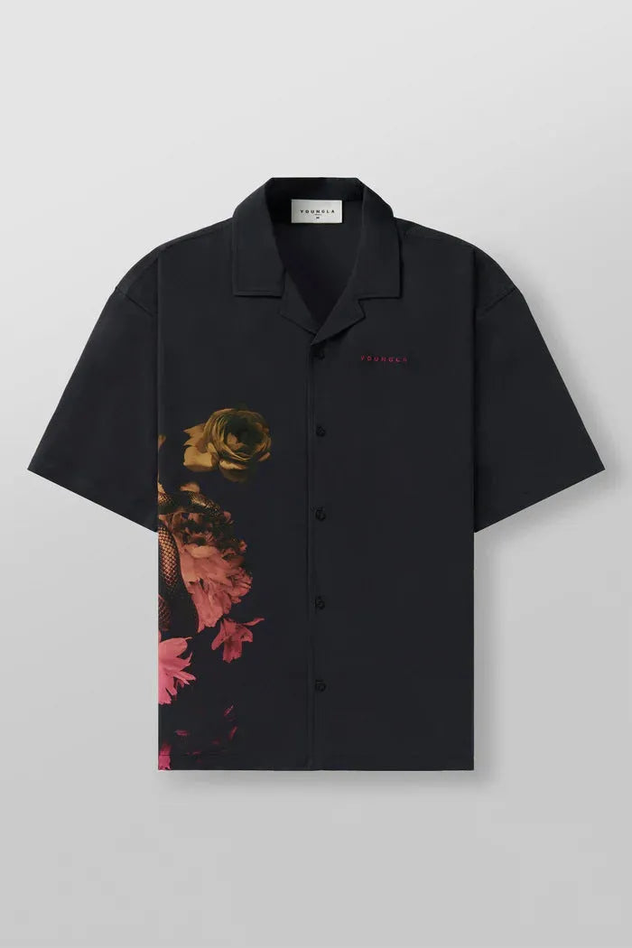 A man's loose-fit short sleeve printed top with a floral pattern, shown in a light colour on a hanger.