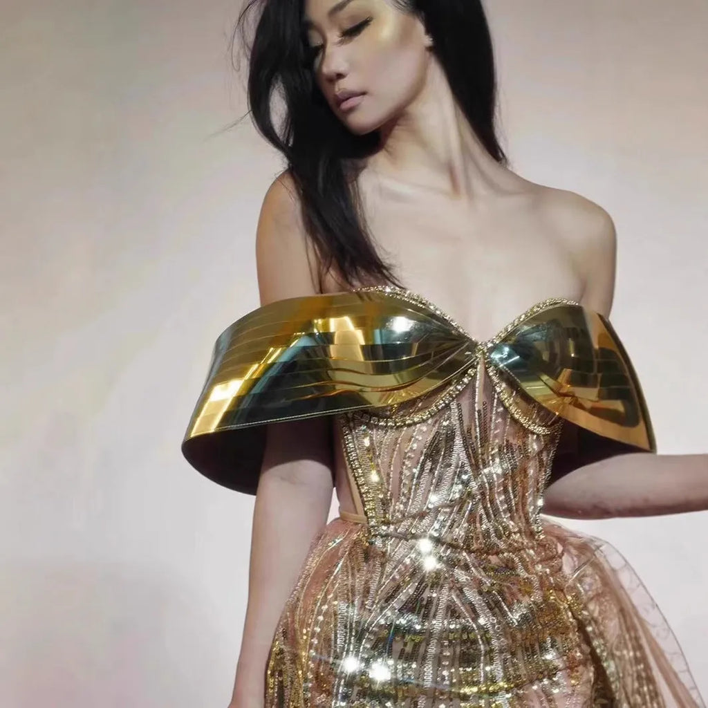Gold sequined strapless evening dress with a thigh-high split in the long tulle skirt.