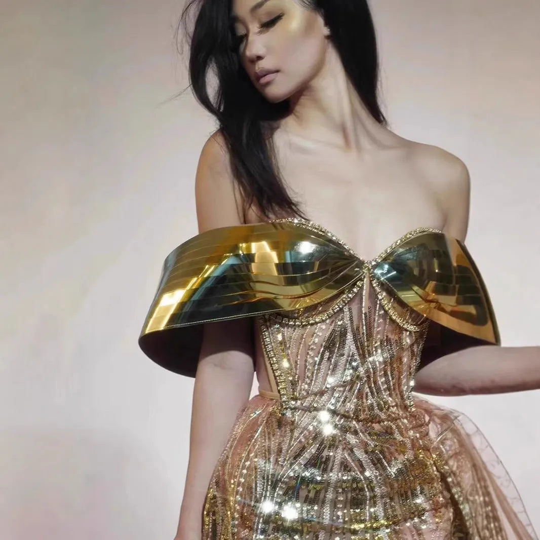 Gold sequined strapless evening dress with a thigh-high split in the long tulle skirt.