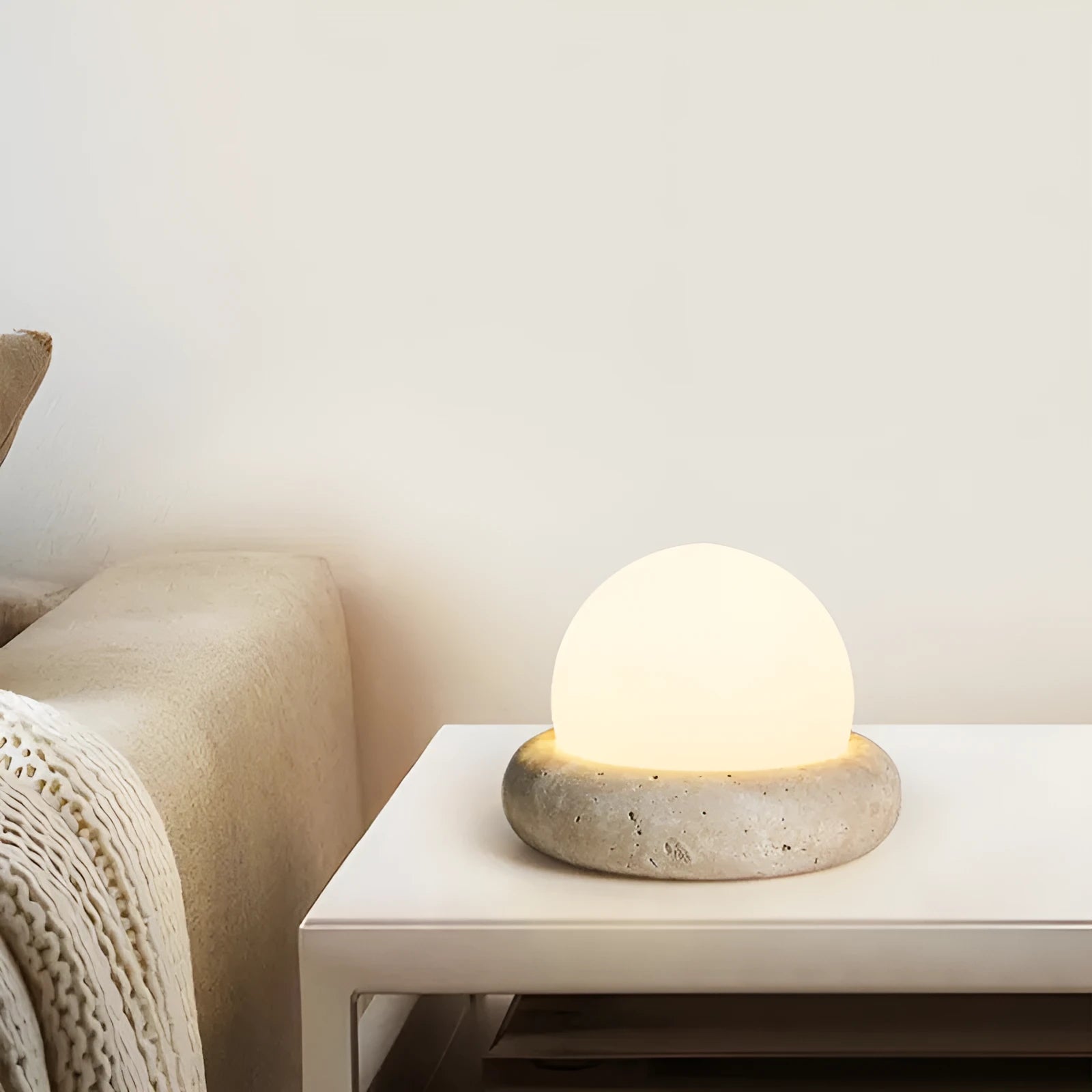 Cream coloured remote control bedside night lamp with yellow cave stone light on wooden table