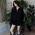 Women's creamy white cable knit sweater and shorts set with geometric pattern on a hanger.