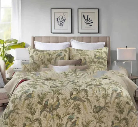 Blue American floral and bird pattern cotton bedspread quilted set of three pieces on a bed.
