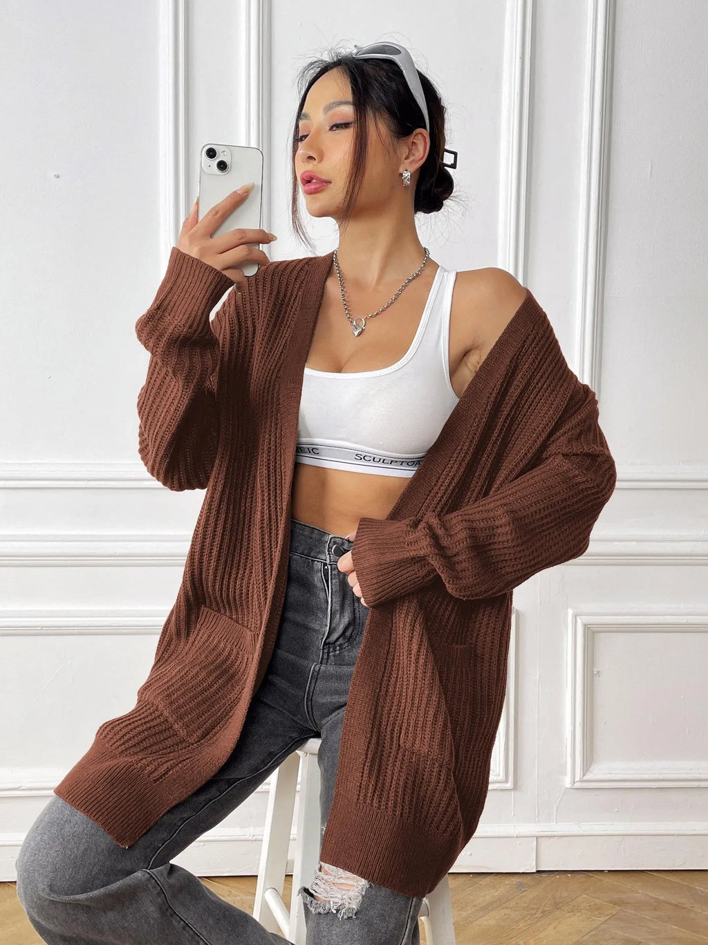 Women's dark green loose-fit acrylic cardigan with double pockets and long sleeves.