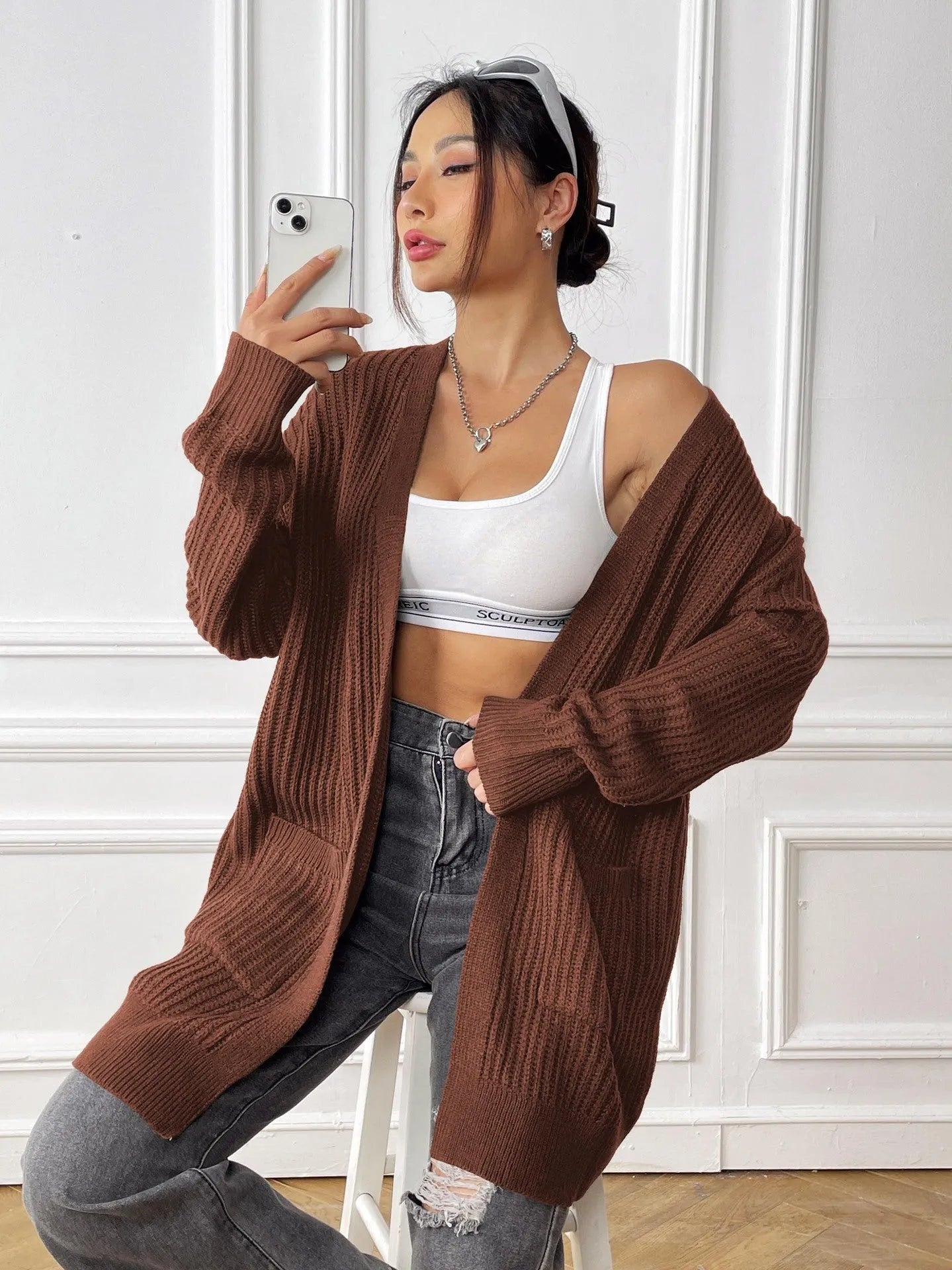 Women's dark green loose-fit acrylic cardigan with double pockets and long sleeves.