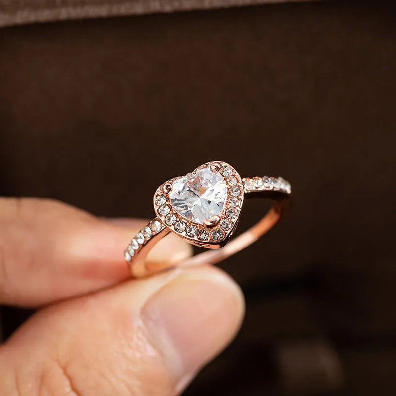 Women's fashion crystal heart-shaped ring in rose gold or silvery on a white background.