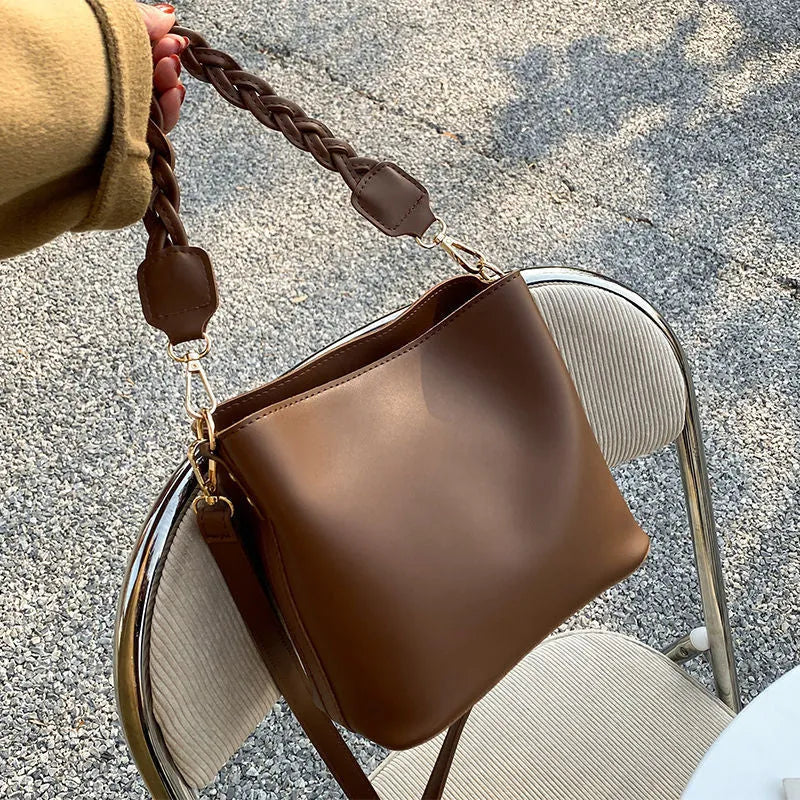 Retro brown bucket bag with weaving pattern, showing crossbody strap and underarm design
