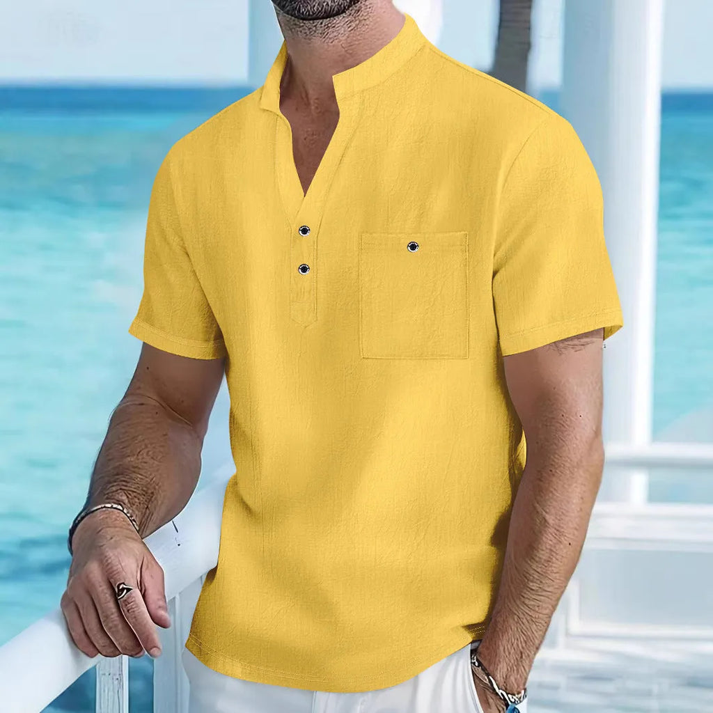 Man wearing a light apricot-coloured linen short sleeve shirt with a stand collar.