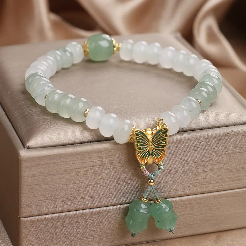 Green crystal women's bracelet with abacus beads, butterfly charm and tassel showing 17cm adjustable purity
