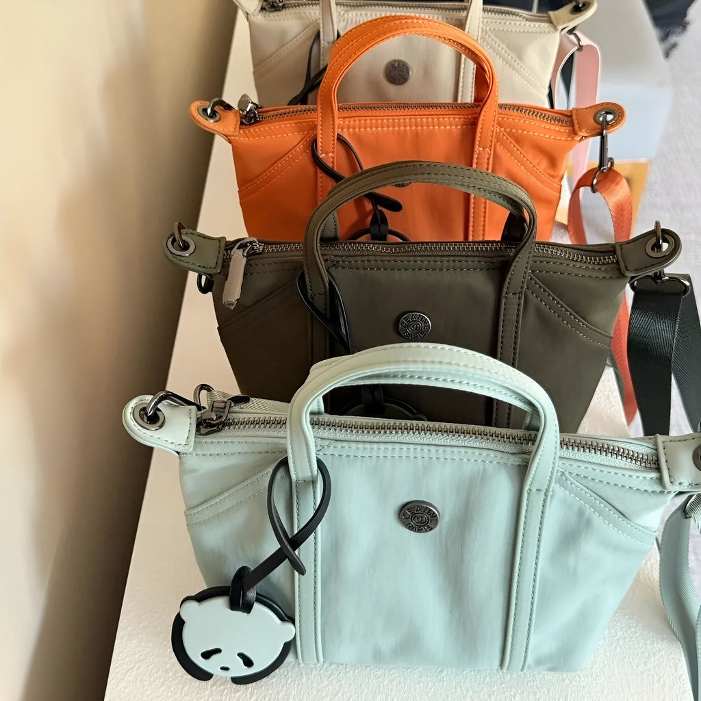 Casual lightweight nylon crossbody bag in dumpling shape, available colours black brown orange pink yellow, with pendant