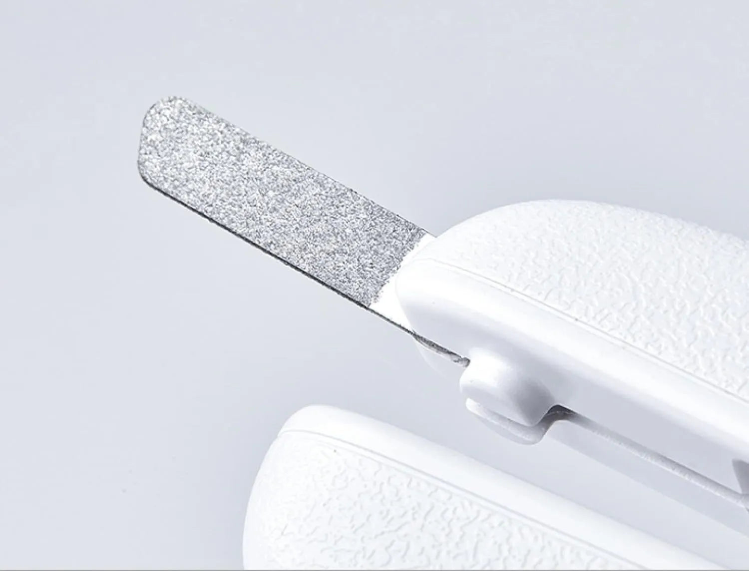 White pet nail clippers with LED light, transparent anti-splash guard, and leather-like handle on a table