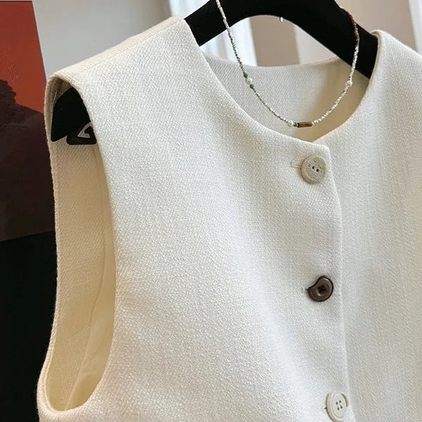 Women's milky white round neck bandage vest made from polyester, laid flat.