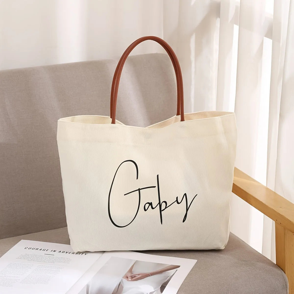 Beige white canvas tote bag with a front zip pocket and sturdy shoulder straps laid flat.